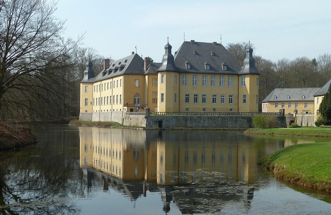 Schloss Dyck bei Jüchen im Frühling, das sich im Wassergraben spiegelt