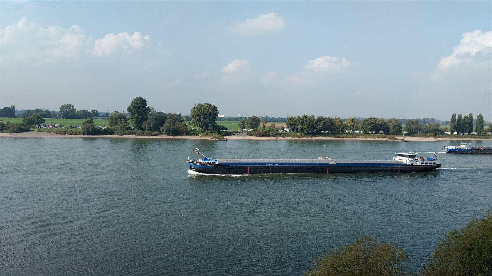 Frachtschiff auf dem Rhein bei Düsseldorf-Kaiserswerth unter leichtem Himmel