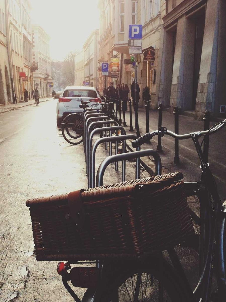 Fahrrad mit Weidenkorb an einer Straße in der Morgensonne