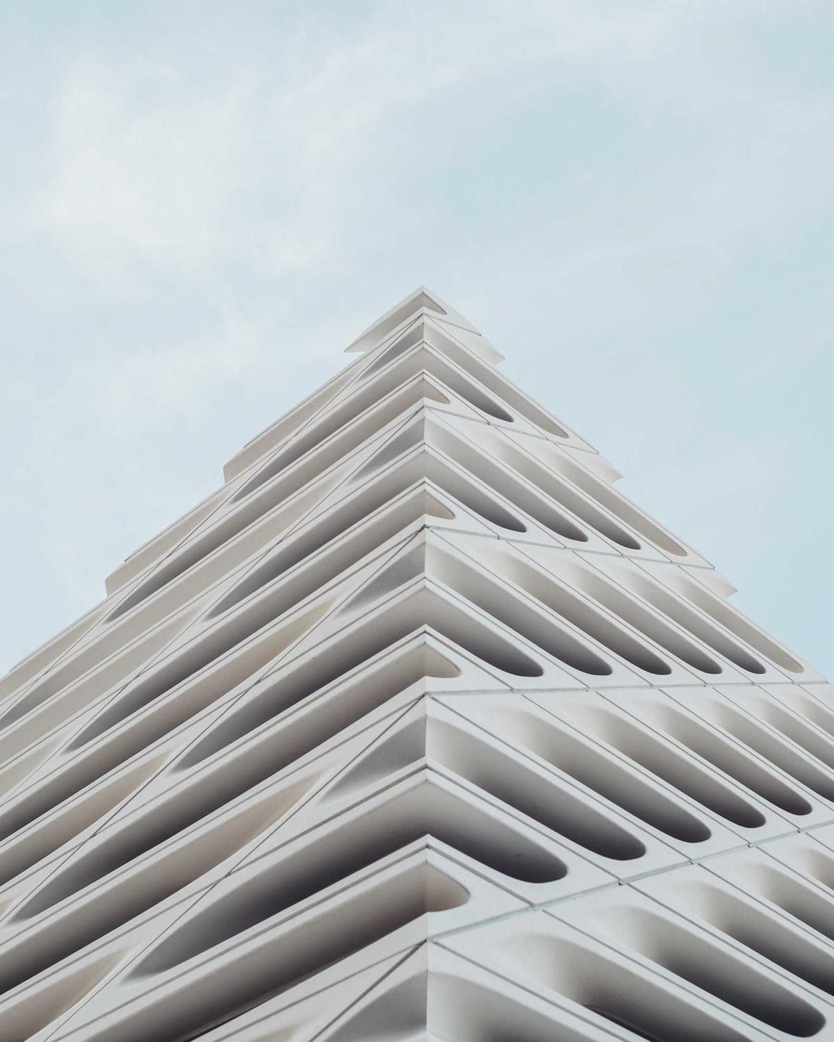 Gestaffelte weiße Hausfassade vor hellblauem Himmel